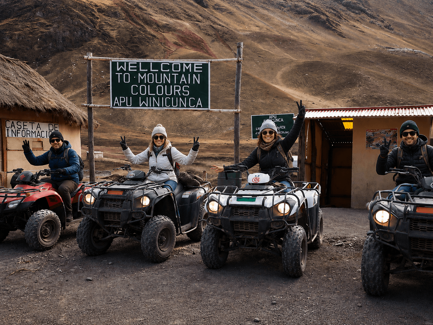 Cuatro viajeros en cuatrimotos frente al letrero de bienvenida de Vinicunca, rodeados por el paisaje de los Andes peruanos.